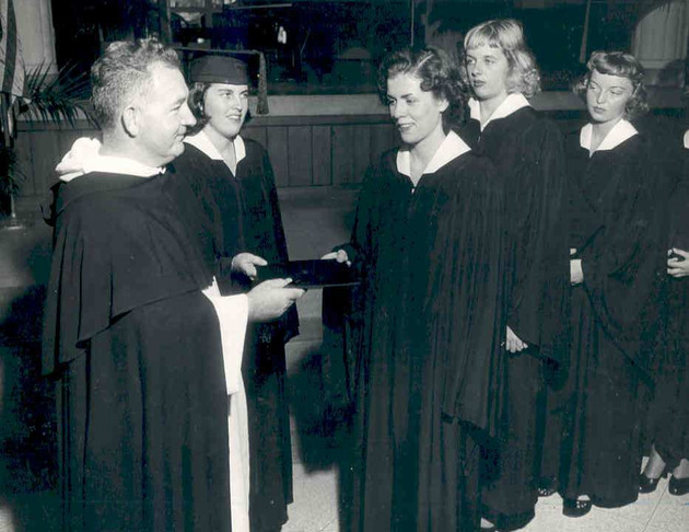 Father Cyril Burke invests freshman class with their caps and gowns
